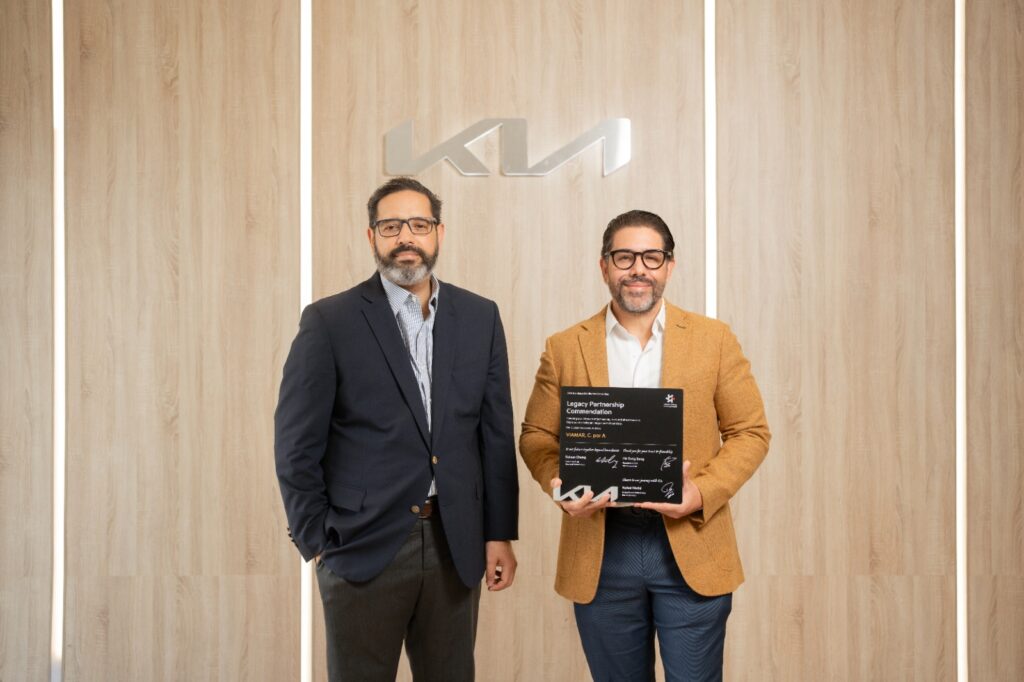 Joan Abreu Peña, vicepresidente de Mercadeo y Ventas de Grupo Viamar, junto a Luis Alexis Ricart, director de KIA para República Dominicana, reciben el reconocimiento
